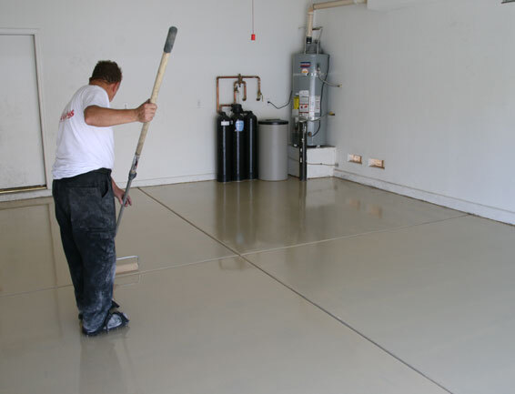 FLOOR EPOXY PROCESS This image shows a man painting a floor with a roller brush.