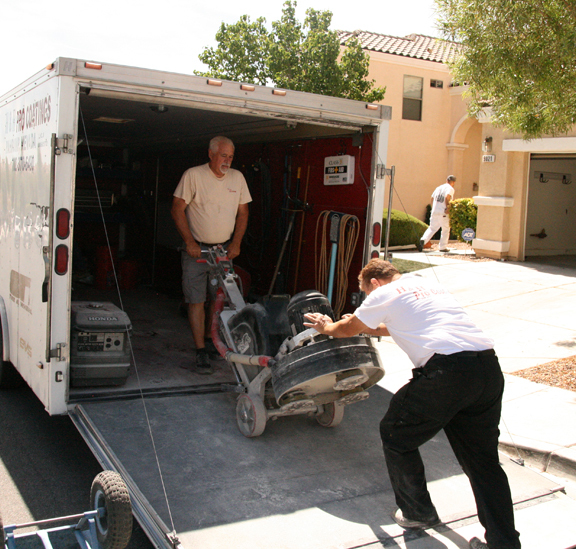 Epoxy Garage Floor Coating This image shows 2 men loading the polishing machine onto a truck.