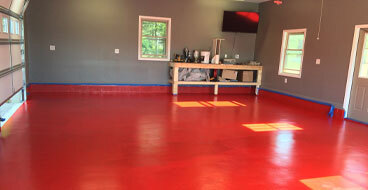 Epoxy-Garage-Floor-Coating This image shows a metallic epoxy floor that is very shiny. The floor's color is red.
