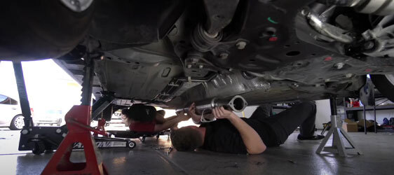 Metallic-Epoxy-Garage-Floor-5 This image shows 2 men installing a muffler on a car.